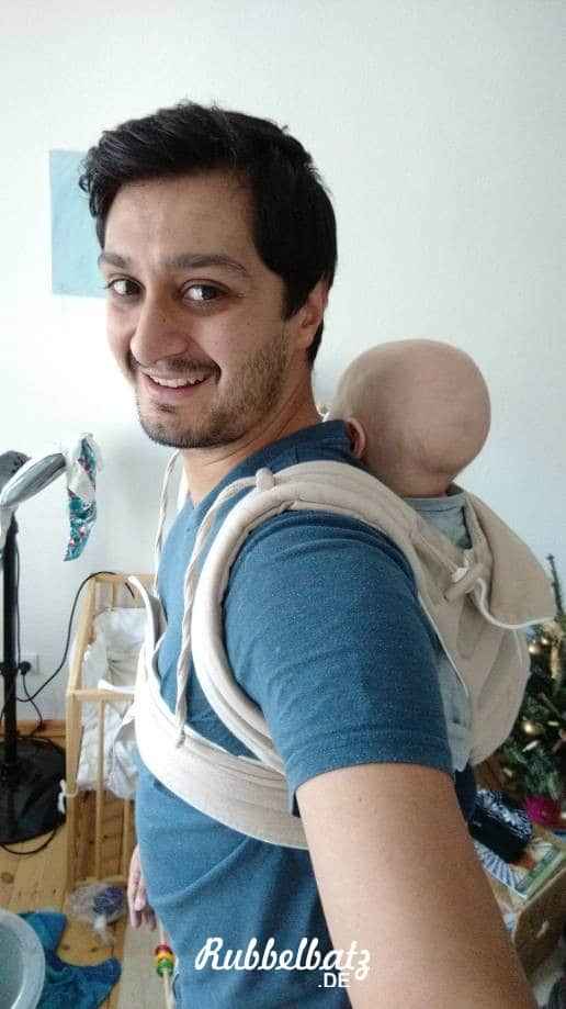 Papa trägt Säugling mit Bondolino Tragesystem auf dem Rücken