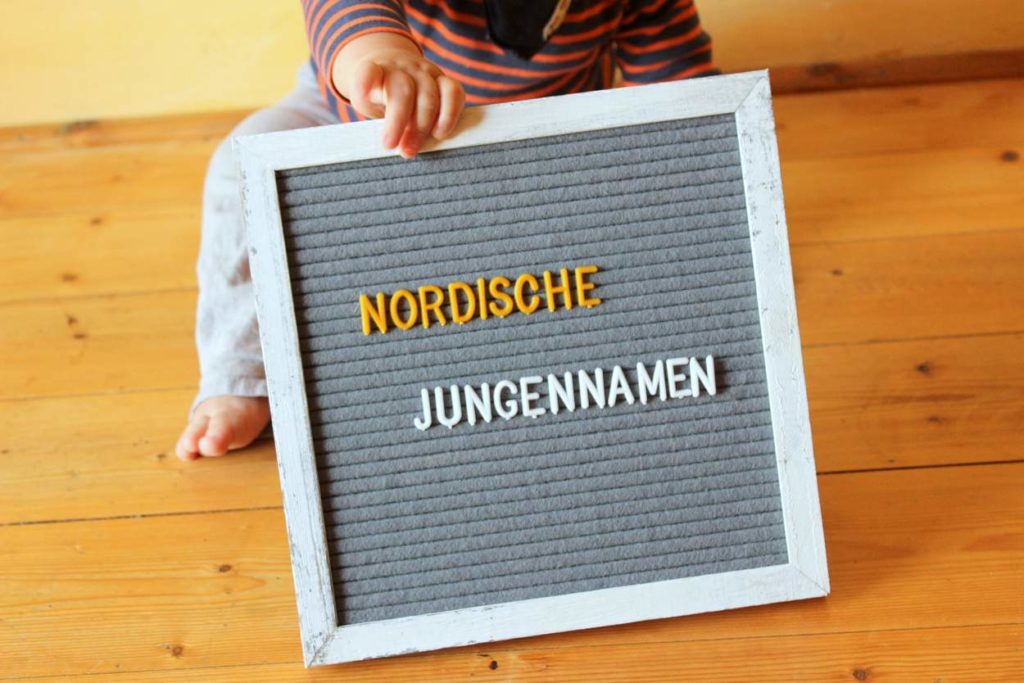 baby junge hält tafel mit aufschrift nordische jungennamen